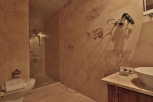 a bathroom with a shower and a toilet and a sink at Guzide Cave Hotel in Göreme +279 photos