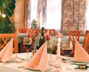 a table with wine glasses and a bottle of wine at Hotel Geier in Bad Schönau