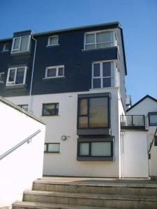 a black and white building with stairs in front of it at Luxury Town Centre Apartment in Kinsale
