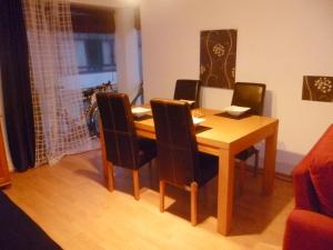 a dining room table with black chairs and a wooden table at Luxury Town Centre Apartment in Kinsale