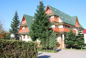 a large house with a green roof at Apartamenty Matuska in Poronin