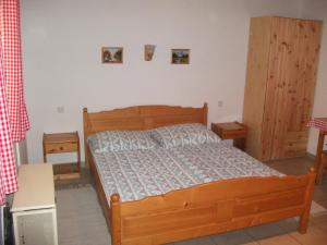 ハイドゥソボスローにあるÁlmos Apartmanのベッドルーム1室(木製ベッド1台、キャビネット2台付)