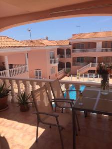 a balcony with a table and chairs and a building at Superior Apartment with Ocean View in Callao Salvaje