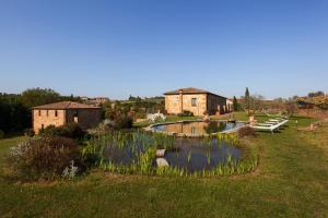 un jardín con un estanque frente a un edificio en Agriturismo La Collina, en Pienza