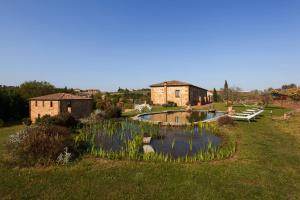 a garden with a pond in front of a building at Agriturismo La Collina in Pienza