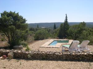 2 Stühle und ein Pool im Hof in der Unterkunft Moulin de maître Cornille in Castillon-du-Gard
