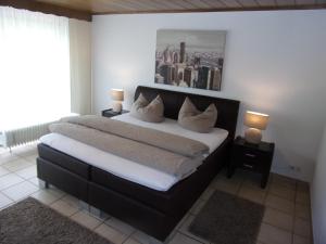 a bedroom with a large bed with white sheets and pillows at Gästehaus Lohmann in Bullay