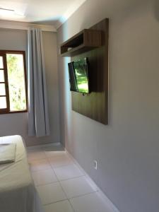 een woonkamer met een tv aan de muur bij AP Beira da Lagoa da Conceição in Florianópolis