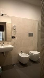 a bathroom with a sink and a toilet and a mirror at B&B Casa D'alleri in Siracusa