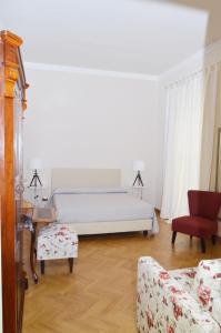 a bedroom with a bed and a couch and a chair at B&B Casa D'alleri in Siracusa