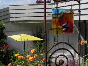 a painting and an umbrella in a garden at B&B Brandholz in Goldkronach