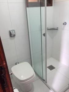 een badkamer met toilet en glazen douche bij AP Beira da Lagoa da Conceição in Florianópolis +25 foto's