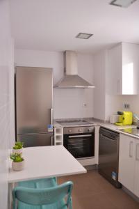 a kitchen with a stainless steel refrigerator and a table at Edimar 9 - Fincas Arena in Benidorm