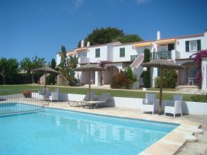 a villa with a swimming pool with chairs and umbrellas at Nure Mar y Mar in Cala en Blanes
