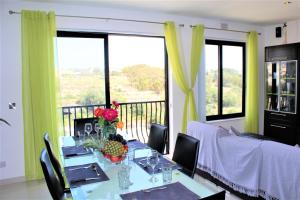 a dining room with a table with flowers on it at Chimes - Gozo Bellevue Homes in Victoria