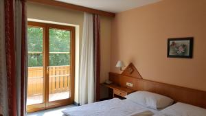 una camera d'albergo con letto e finestra di Hotel Geier a Bad Schönau