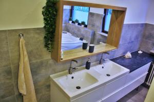 ein Badezimmer mit Waschbecken, Spiegel und Badewanne in der Unterkunft Apartment am Römerkreis in Heidelberg + 17 Fotos