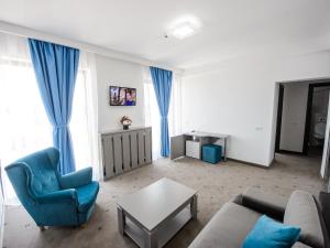 a living room with a blue couch and a table at Vila La Mer Mamaia Nord in Mamaia Nord
