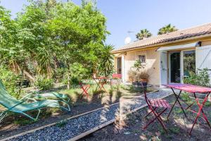 a group of chairs and a table in front of a house at Villa Trou Aux Biches in Oletta