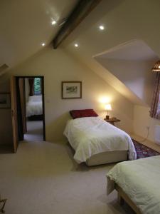 a attic bedroom with two beds and a mirror at Sunrise House in Inverfarigaig