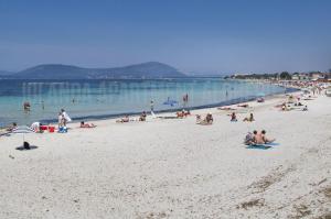 a group of people on a beach in the water at Iolanda Apartment 30m from Seaside in Alghero