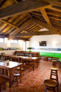 un restaurante con mesas de madera y sillas en una habitación en Albergue do Xurés, en Maus de Salas