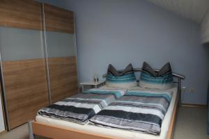 ヴァイセンスベルクにあるFerienwohnung Ausblickのベッドルーム(青い枕のベッド1台付)