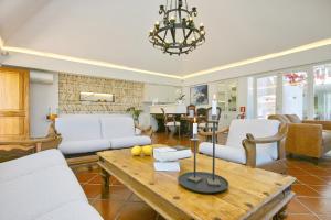 a living room with white furniture and a table at Hotel Rural Can Maries in Puerto de San Miguel