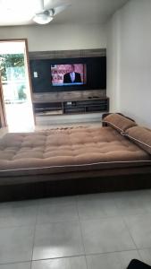 un gran sofá marrón en una sala de estar con TV en Temporada - Cabo Frio, en Cabo Frío