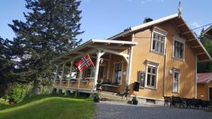 una casa con una bandera en la parte delantera en Eidsfoss slusevokterbolig, en Lunde