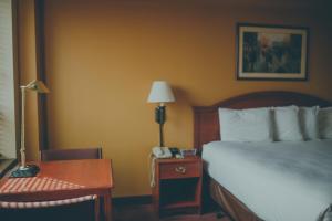 a hotel room with a bed and a desk with a phone at The Hotel Ottumwa in Ottumwa