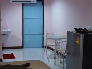 a room with a blue door and a table and chairs at Smile Resort in Ban Phai Cham Sin