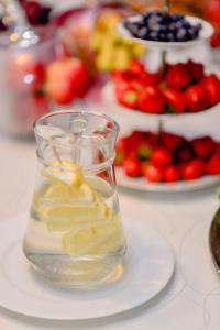 a glass vase filled with water on top of a plate at Astra Hotel in Klaipėda