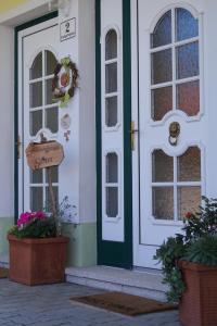 einer Haustür eines Hauses mit Topfpflanzen in der Unterkunft Ferienwohnung Sissi in Frauenkirchen