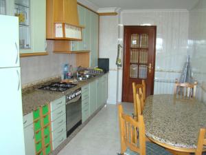 a kitchen with green cabinets and a table with a counter top at Apartamento Valle Inclán in Vilagarcia de Arousa