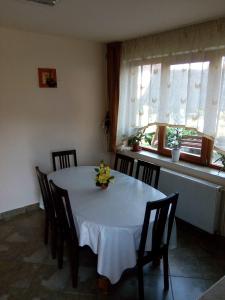 - une table à manger avec une nappe et des chaises blanches dans l'établissement Casa Toma, à Sovata