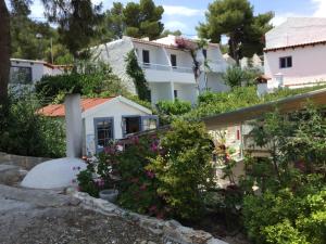 a house on a hill with flowers and bushes at Rosys Little Village in Skala