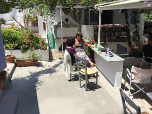 two women sitting at a table in a flower shop at Rosys Little Village in Skala