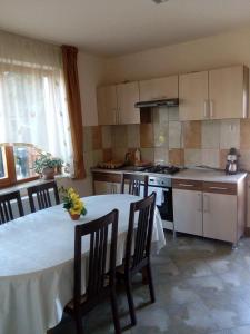 een keuken met een tafel en stoelen en een keuken met een fornuis bij Casa Toma in Sovata