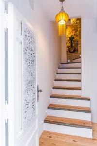a staircase with a white door and a chandelier at Blancos Rooms Hotel in Peniscola