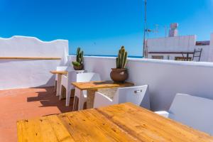 a row of tables and chairs on a balcony with cactus at Blancos Rooms Hotel in Peniscola +63 photos