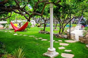 a garden with a pole and a hammock in the grass at Terrace Apartment in Hvar