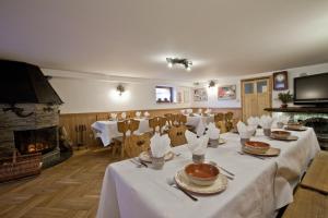 a dining room with tables and chairs and a fireplace at Apartamenty Matuska in Poronin