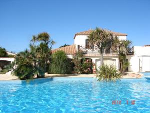 a swimming pool in front of a house at Alizés in Saint-Denis-dʼOléron