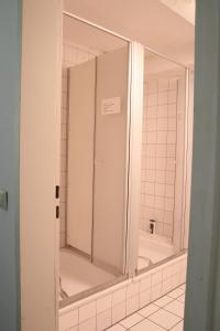 a bathroom with a large mirror in a shower at Pauli Hostel in Hamburg