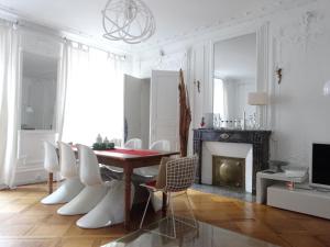 comedor con mesa, sillas y chimenea en Les Serruriers - Appartement Spacieux avec Terrasse & Parking, en Estrasburgo