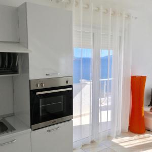 eine Küche mit einem Herd und einem Fenster in der Unterkunft White Residence Apartament in Sarandë
