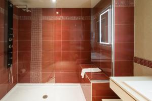 a bathroom with a shower with a tub and a sink at Le Chabrol Hotel & Suites in Montreal