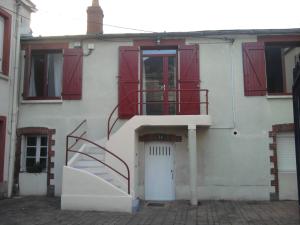 ein weißes Haus mit roten Türen und einer Treppe in der Unterkunft Chambres Zola in Nantes