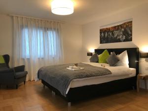 a bedroom with a large bed and a chair at Ferienhaus Vier Jahreszeiten in Bad Urach